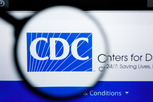 Magnifying glass over CDC logo on a website.