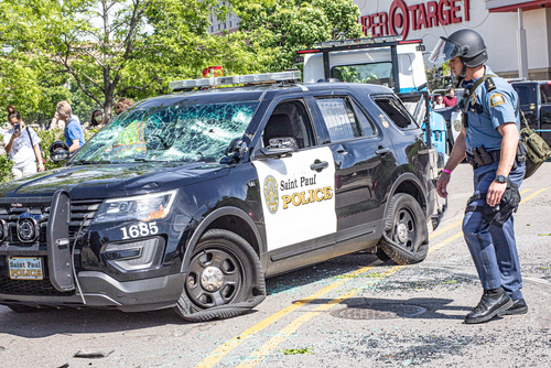 Damaged Saint Paul Police car with officer nearby.