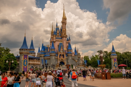 Crowd at Magic Kingdom's Cinderella Castle on a cloudy day.