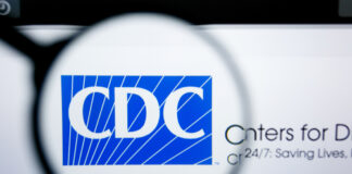 Magnifying glass over CDC logo on a website.