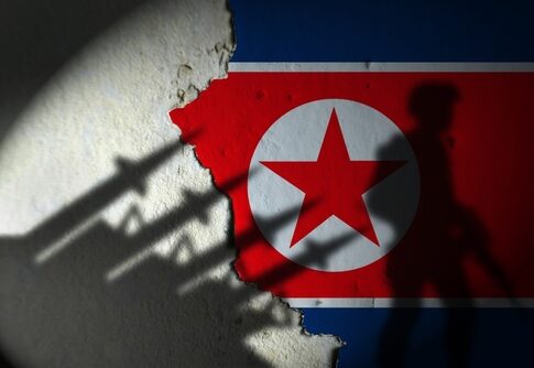 North Korean flag with soldier silhouette in shadow.